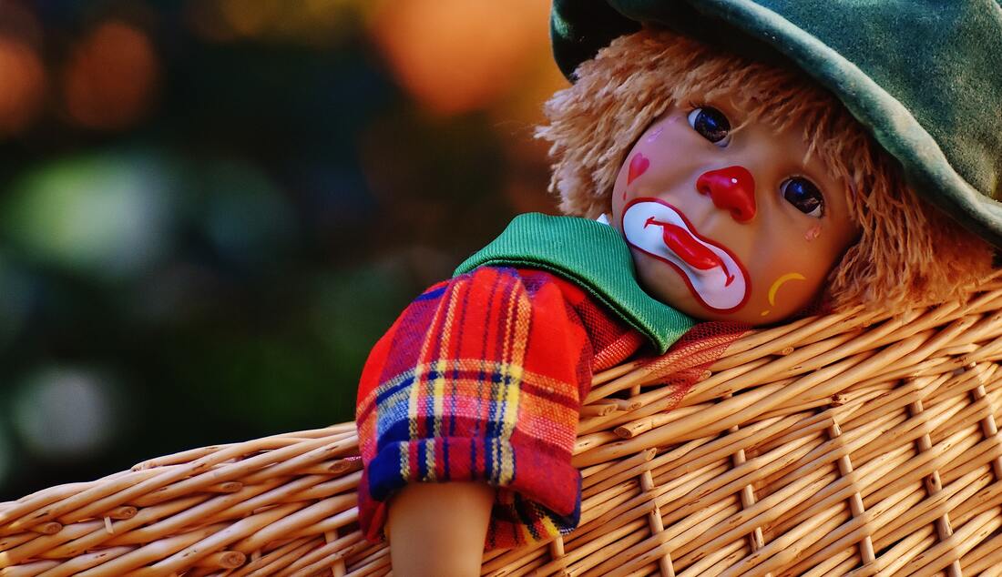 Sad clown doll in a basket