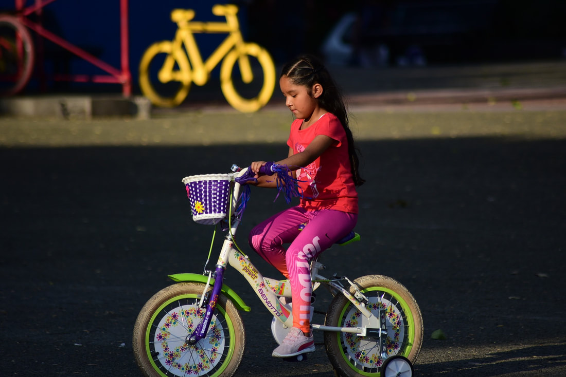 Young Latina girl riding a bicycle.