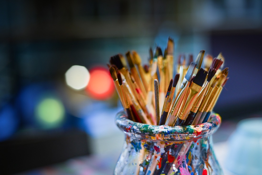 paintbrushes in a dirty jar