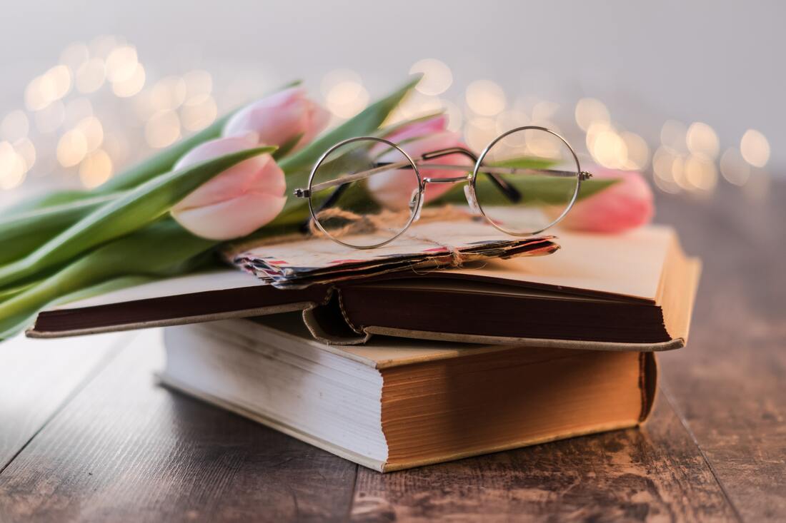 Eyeglasses and tulips on a small stack of books